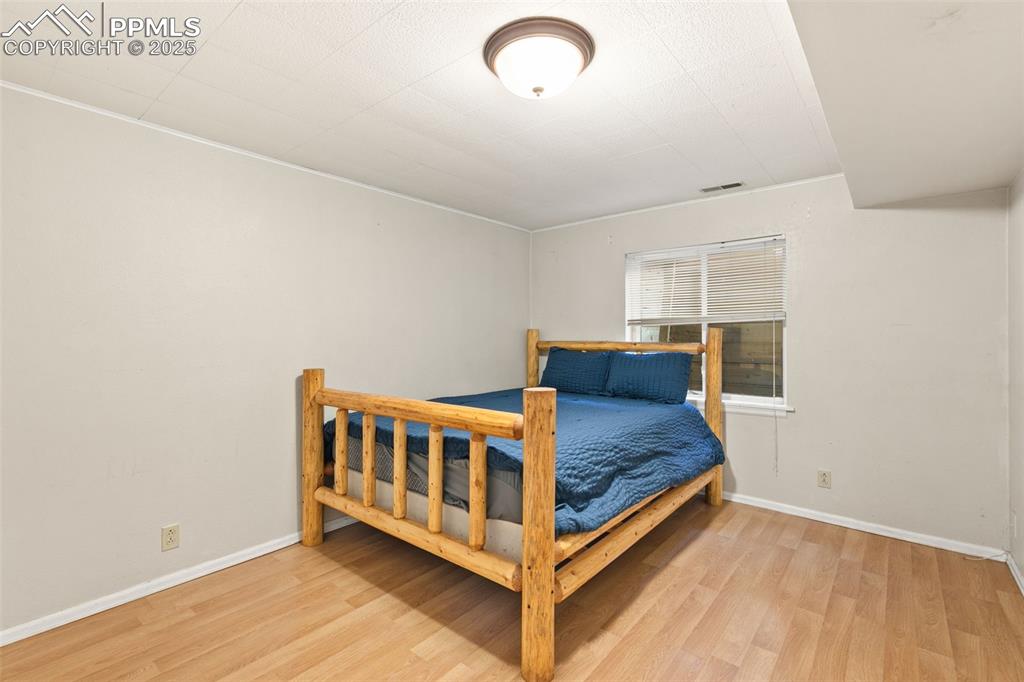 Image 33 of 36: Bedroom featuring light wood-type flooring and ornamental molding