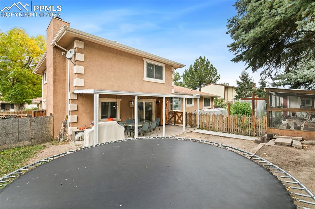Image 36 of 36: Back of house featuring a patio, stucco siding, a chimney, and outdoor dini