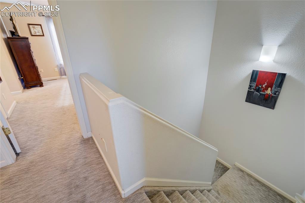 Image 15 of 42: Hall with light colored carpet and an upstairs landing
