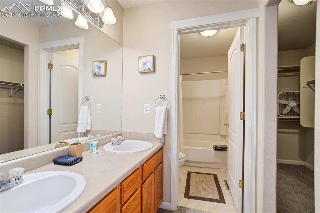 Image 20 of 42: Full bathroom featuring a spacious closet, double vanity, and bathtub / sho