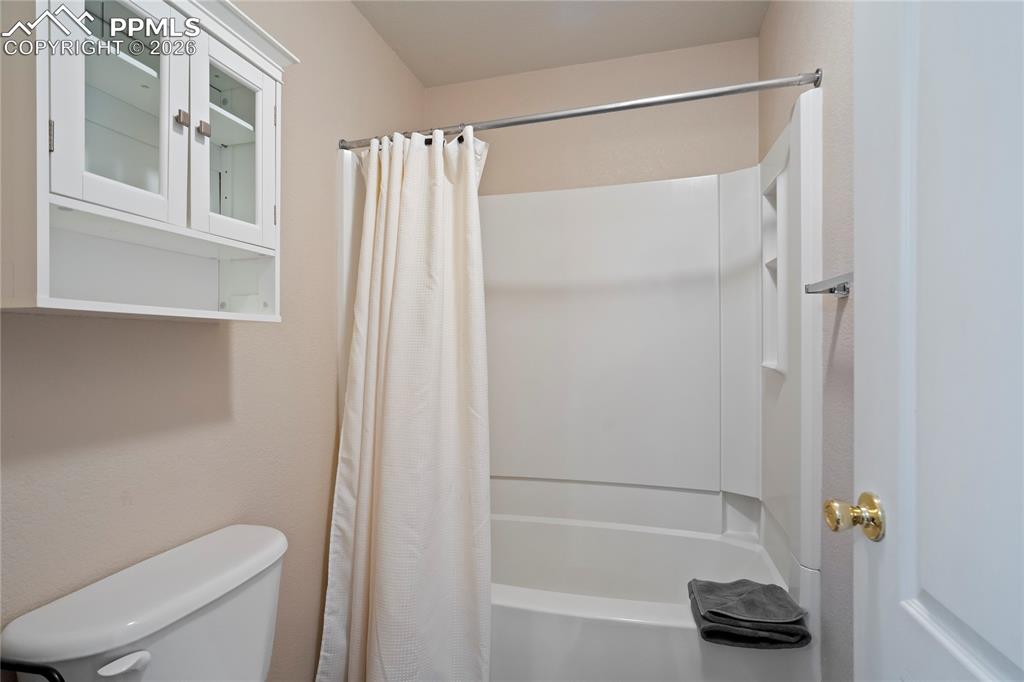 Image 22 of 42: Full bath featuring shower / bath combo with shower curtain and toilet