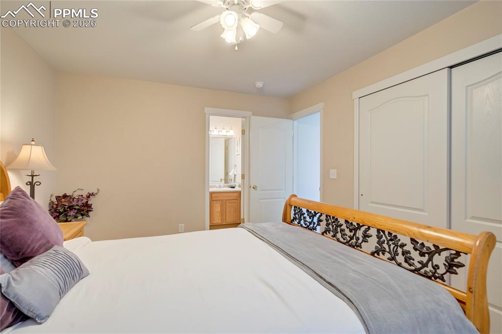 Image 28 of 42: Bedroom featuring a closet, ceiling fan, and ensuite bath