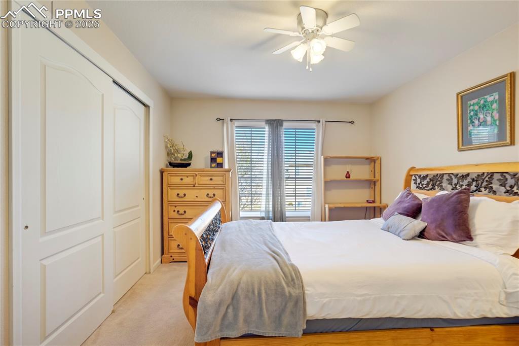 Image 30 of 42: Bedroom with light carpet, a closet, and ceiling fan