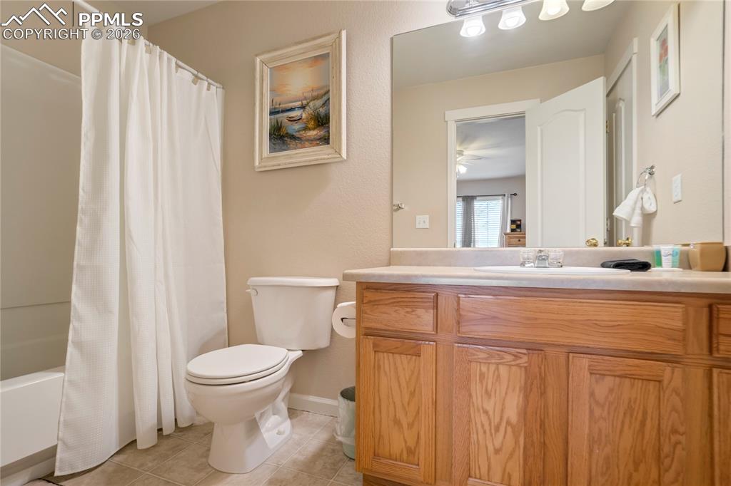 Image 32 of 42: Full bath with shower / bath combination with curtain, vanity, and light ti