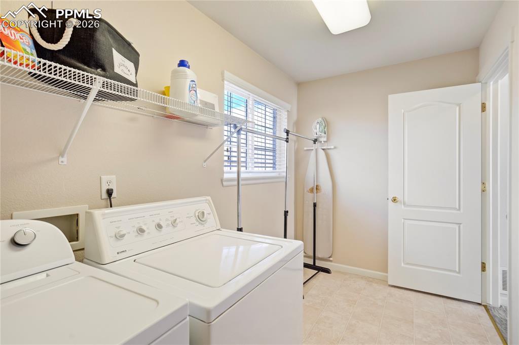 Image 33 of 42: Laundry room featuring washing machine and clothes dryer and baseboards