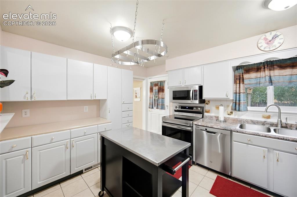 Image 12 of 47: Spacious counter tops and window over the sinks looks into the backyard. 