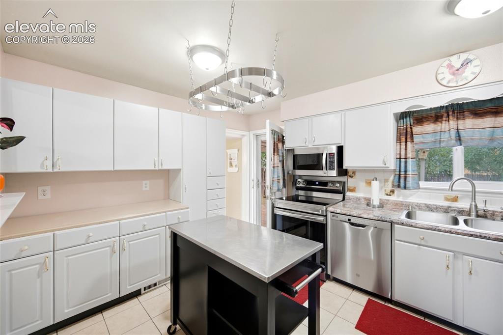 Image 13 of 47: Extra Cabinetry in the kitchen. Bonus with movable island and Hanging Pan R