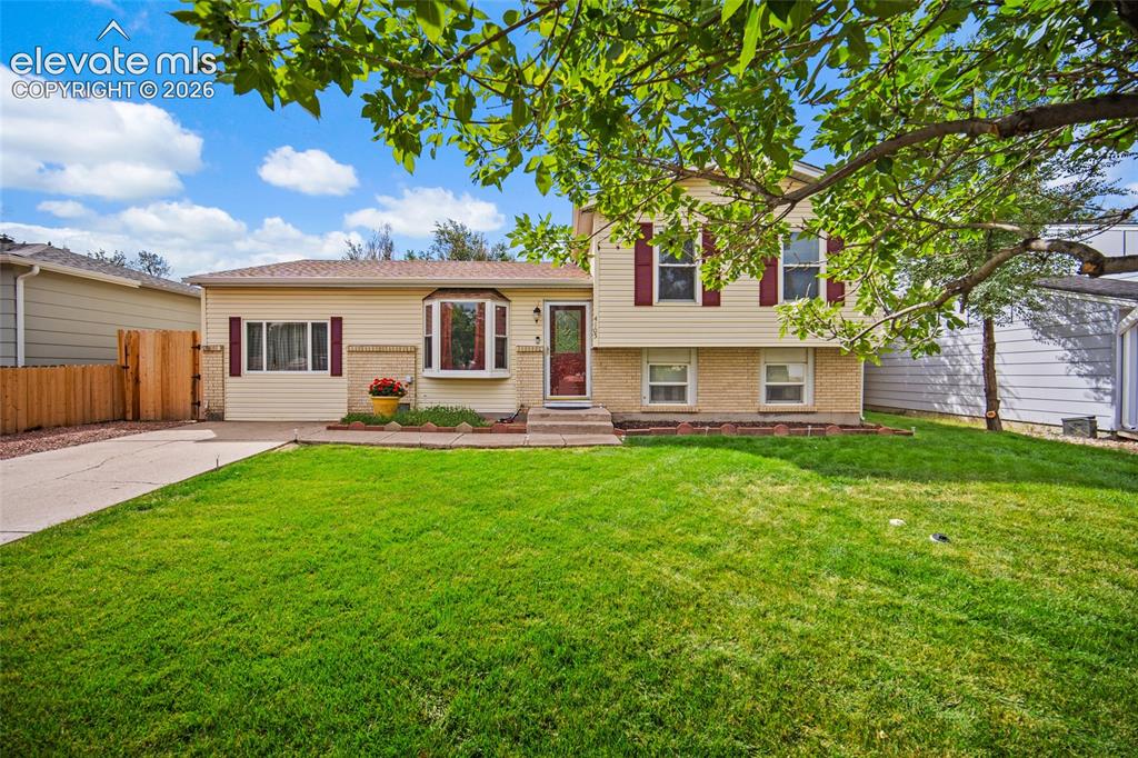 Image 3 of 47: Lush green grass with front yard sprinkler system. 