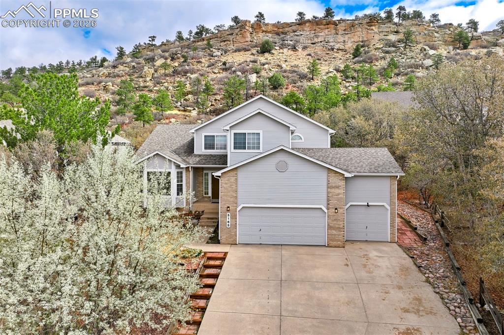 Image 1 of 44: Two-story residence featuring light gray siding, a two-car garage, and a si