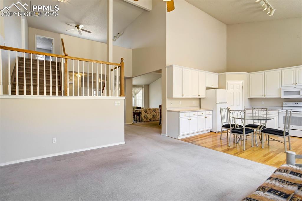 Image 12 of 44: Vaulted ceilings complement the open-concept living space with carpeted flo