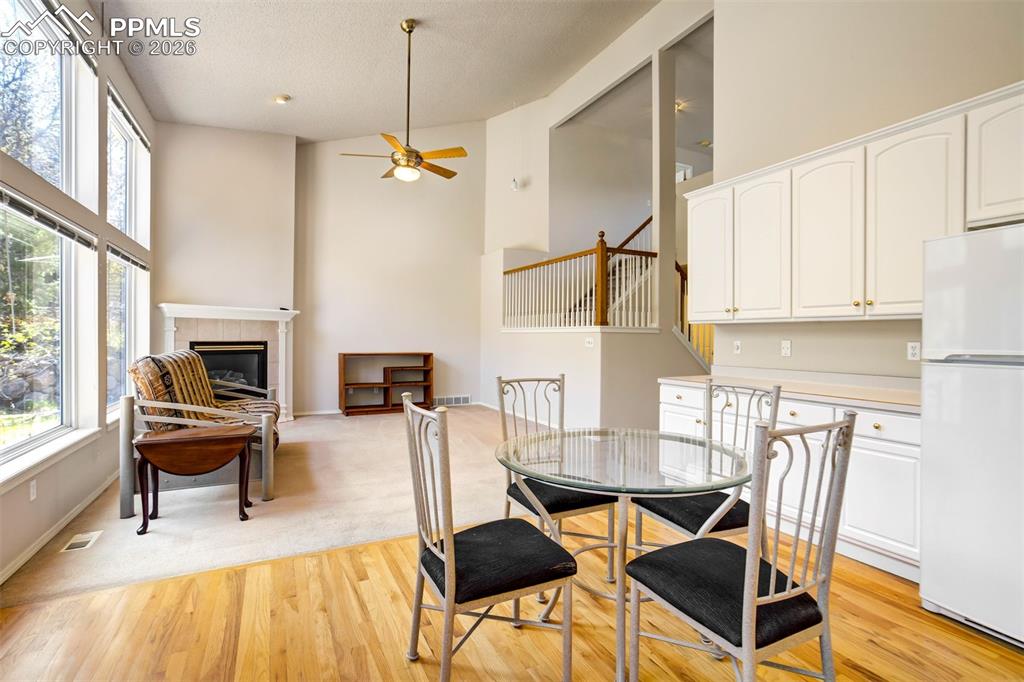 Image 15 of 44: Open concept living area with hardwood-finish flooring, a fireplace with a 