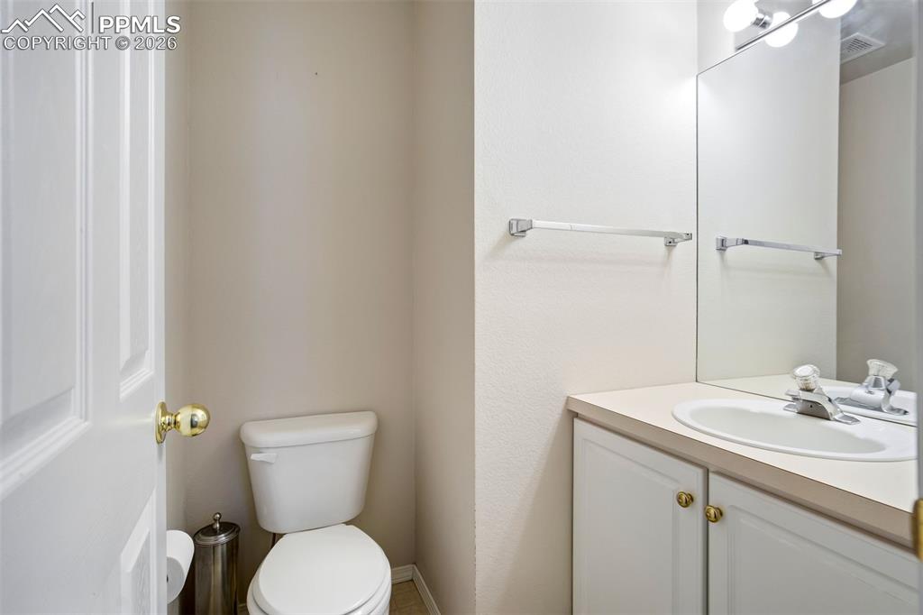 Image 16 of 44: Powder room featuring a white single-basin vanity with base cabinetry, an i