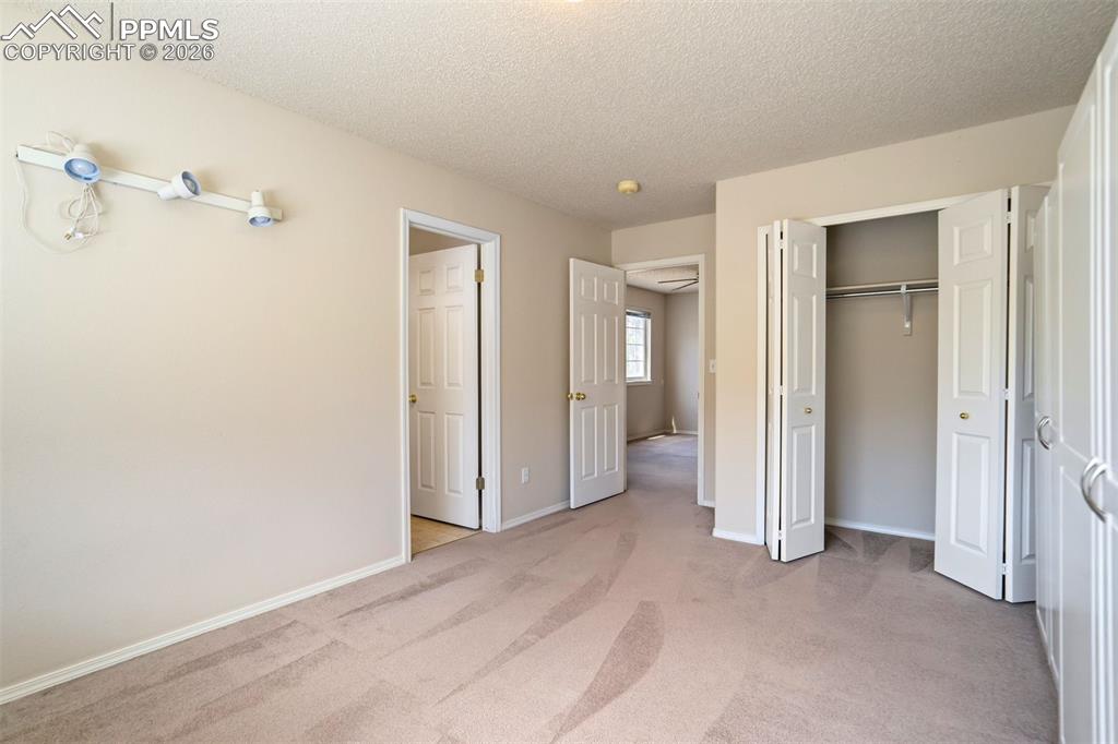 Image 25 of 44: Carpeted interior space featuring neutral wall paint, closet & bathroom ent