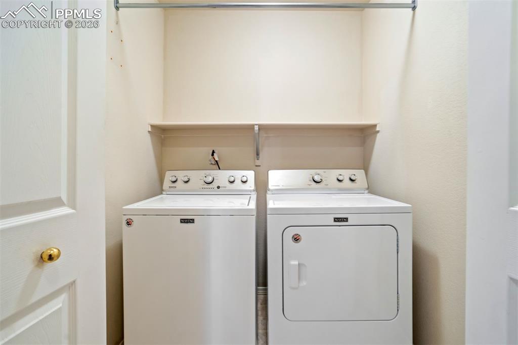 Image 29 of 44: Laundry area featuring a top-load washing machine and front-load dryer