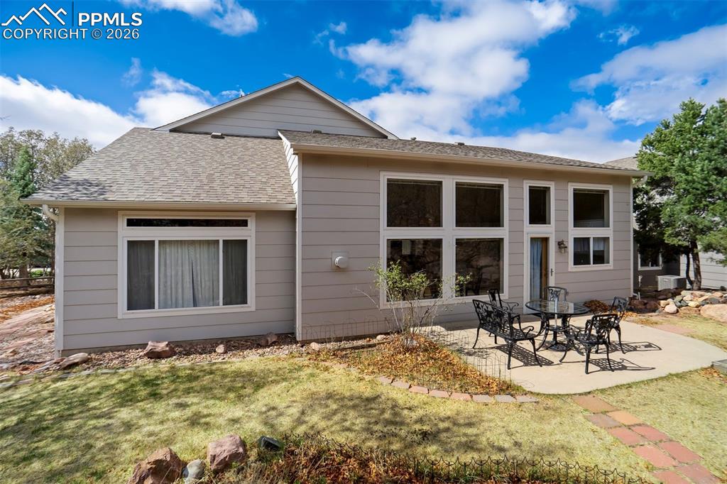 Image 31 of 44: Rear exterior featuring many windows, a concrete patio, light-colored sidin