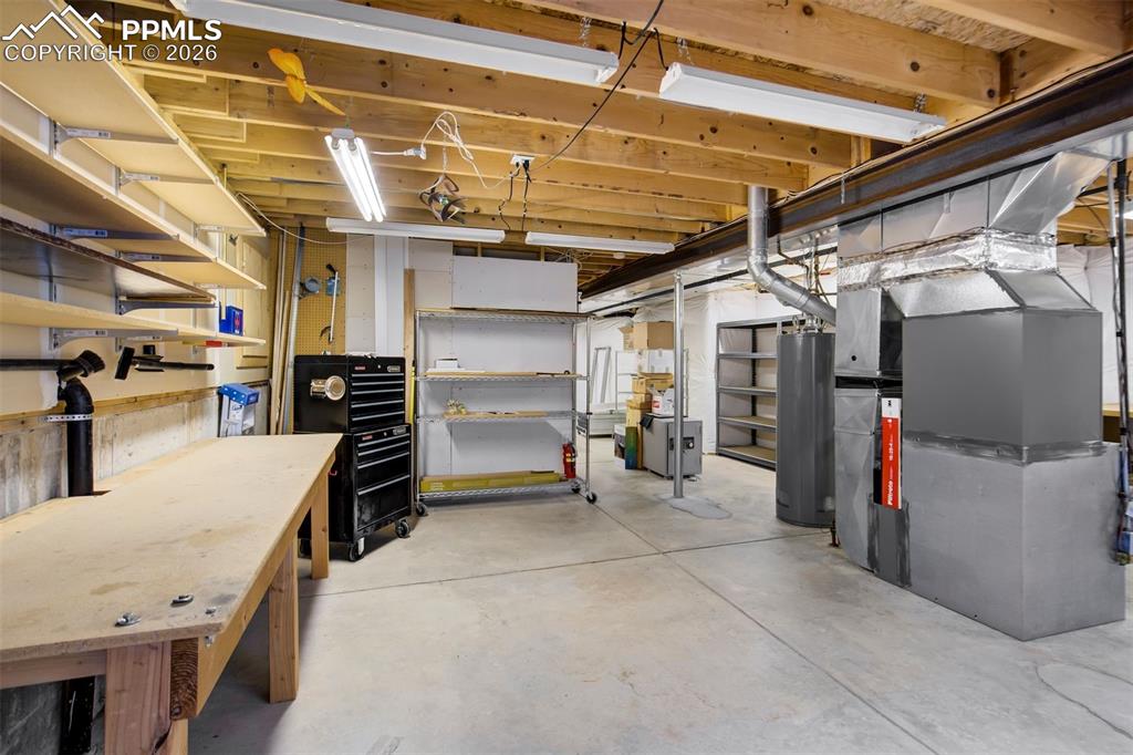 Image 38 of 44: Unfinished basement space featuring exposed wooden ceiling joists, concrete