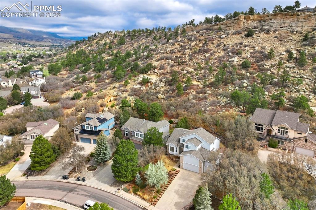 Image 40 of 44: Residential properties nestled into a natural, tree-covered hillside with d