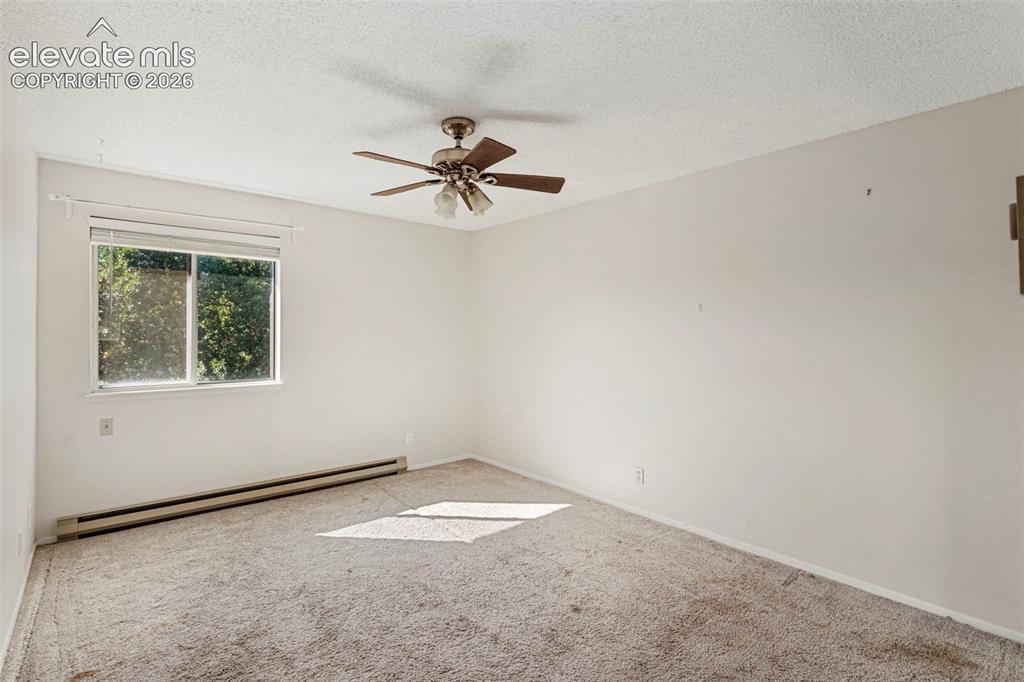 Image 12 of 18: Ceiling fan with light fixture, wall-to-wall carpeting, and baseboard heati