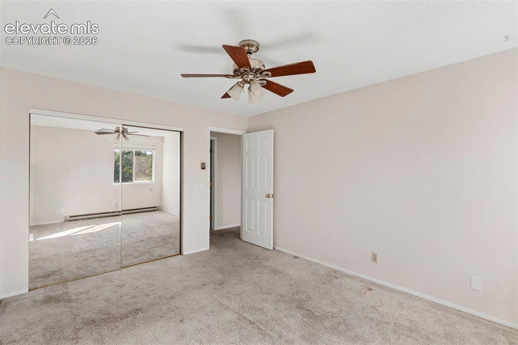 Image 13 of 18: Wall-to-wall carpeting with mirrored closet doors and a ceiling fan
