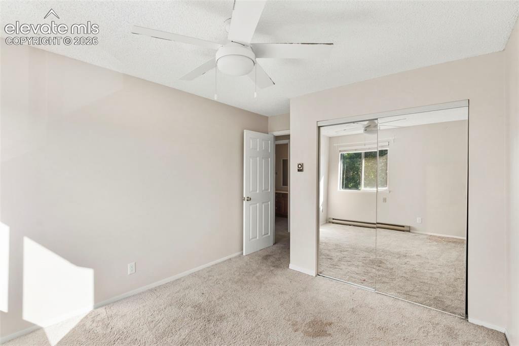 Image 16 of 18: Room featuring a ceiling fan, neutral wall paint, and mirrored closet doors