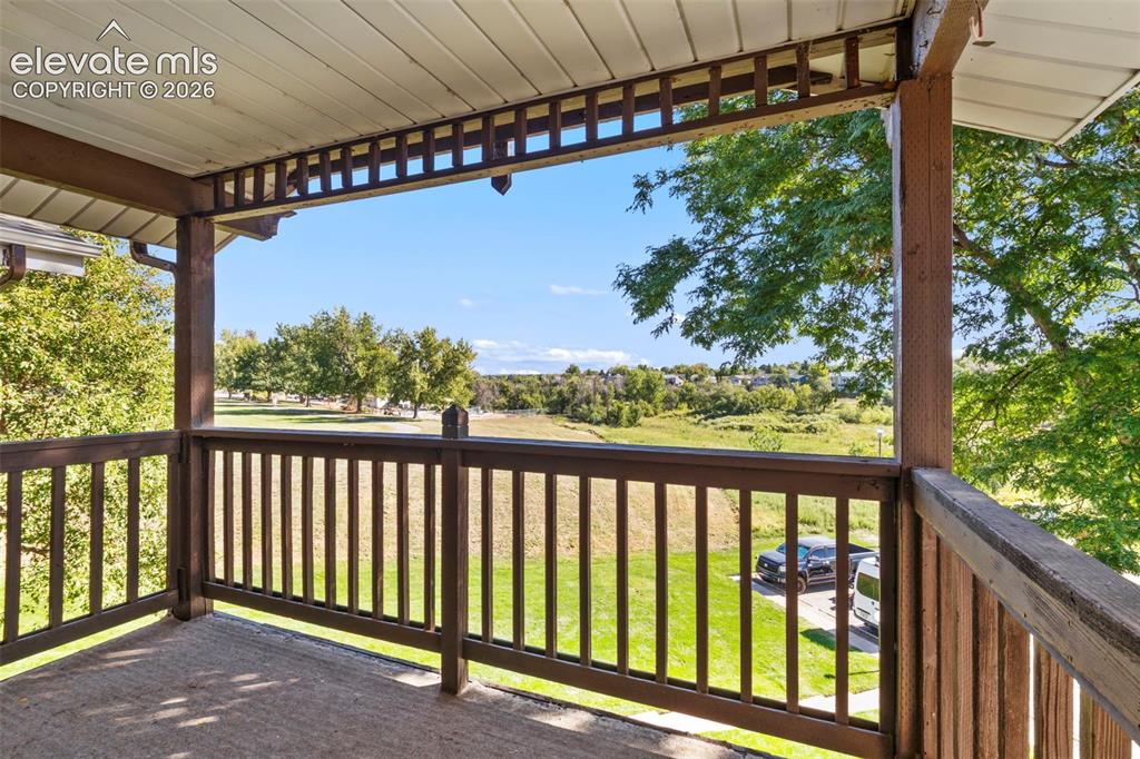 Image 18 of 18: Covered balcony with wood railings and open outdoor scenery
