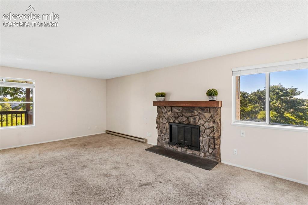 Image 5 of 18: Stone-faced fireplace with a wood mantel