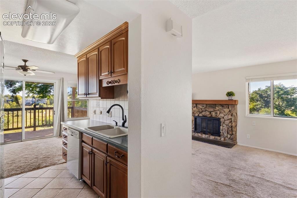 Image 8 of 18: Kitchen with wood cabinetry, dual basin sink, and tile flooring