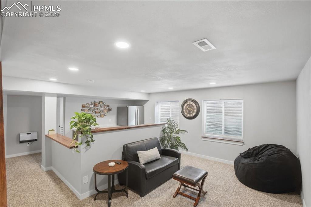 Image 27 of 40: Spacious basement family room with recessed lighting and flexible living sp