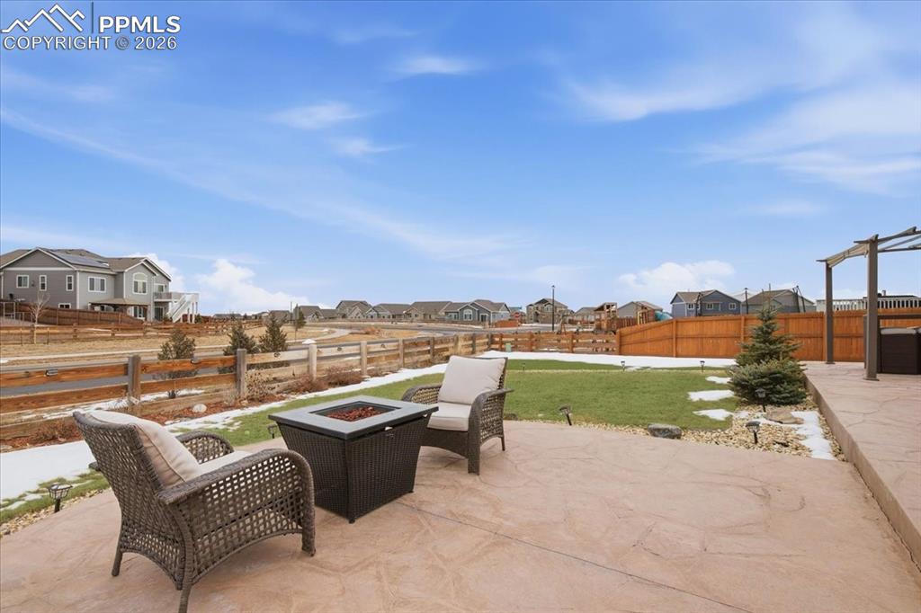 Image 7 of 40: Stamped concrete patio with built in fire pit and gas line, creating a perf