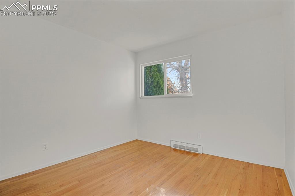 Image 18 of 37: Second bedroom with hardwood floors