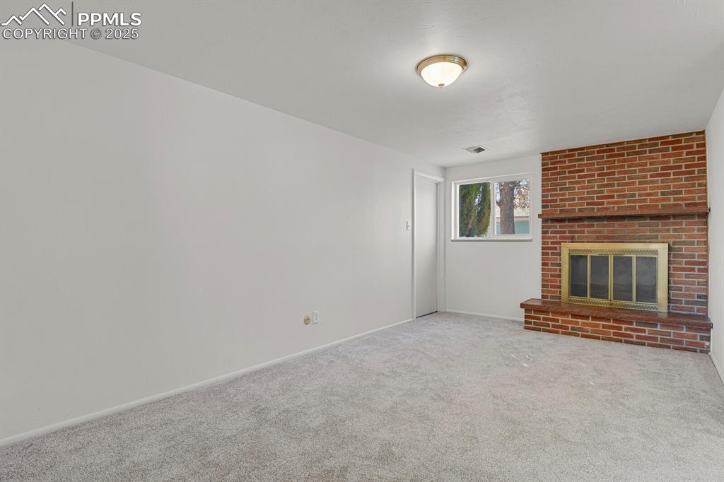 Image 21 of 37: Large family room in lower level with wood burning fireplace