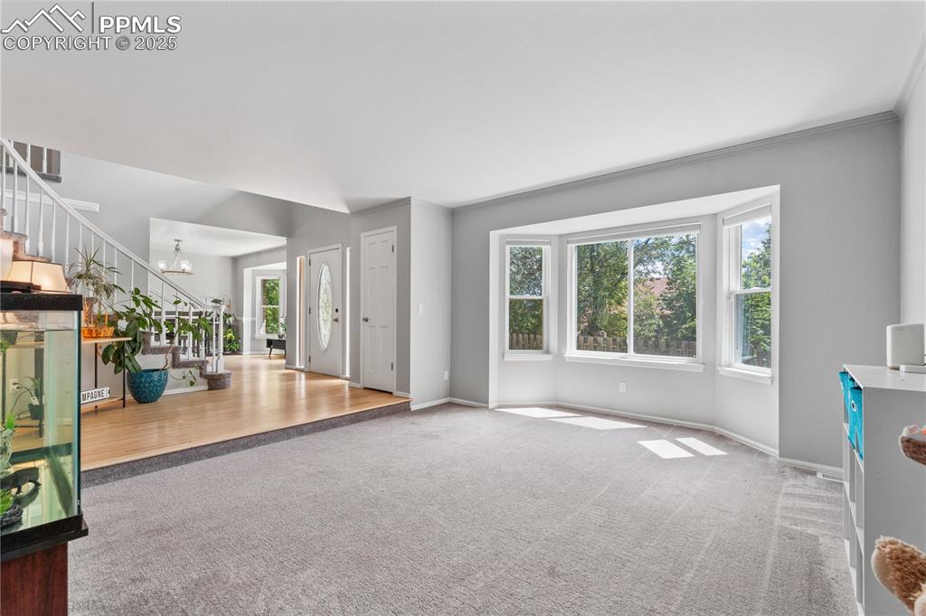 Image 10 of 50: Entrance foyer featuring carpet floors, stairs, plenty of natural light, an