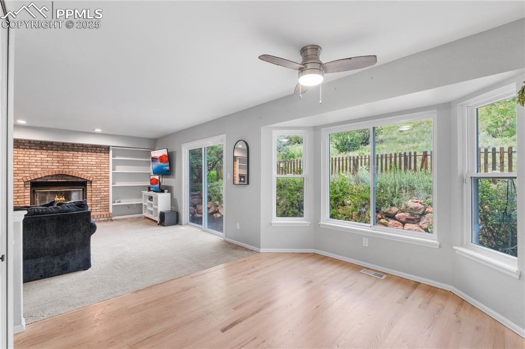 Image 16 of 50: Unfurnished living room with a brick fireplace, light wood-style flooring,
