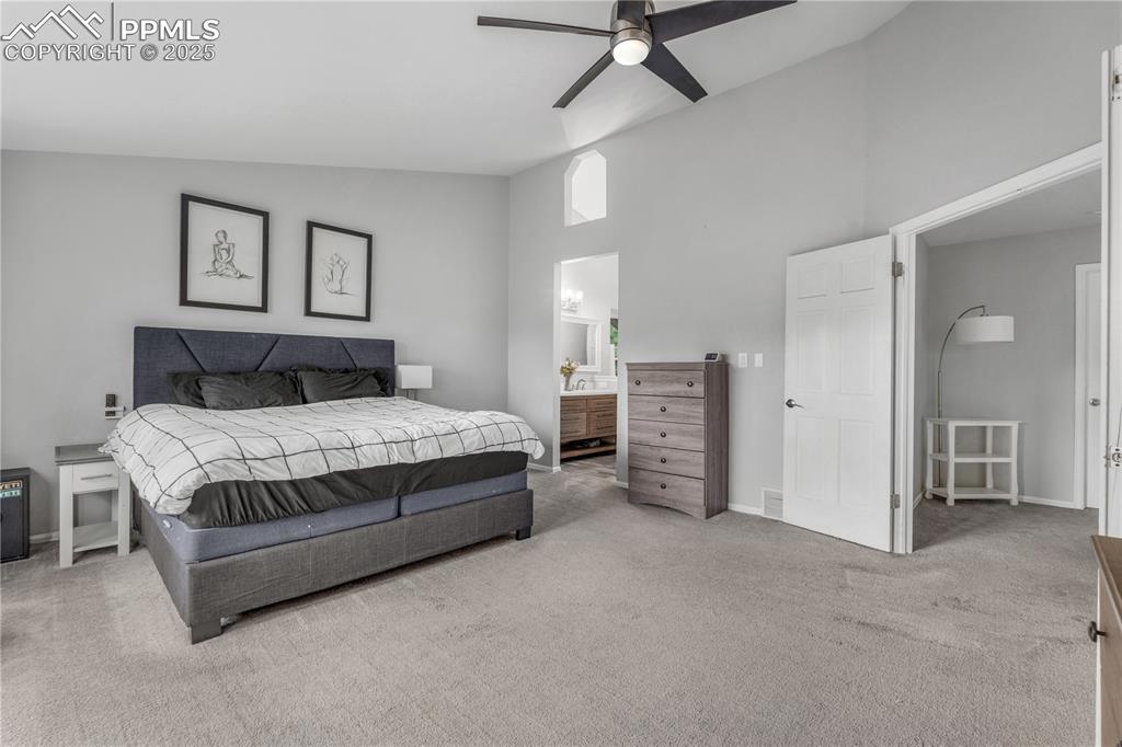 Image 23 of 50: Bedroom featuring carpet flooring, high vaulted ceiling, ensuite bathroom,
