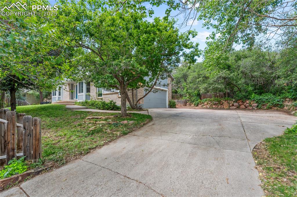 Image 41 of 50: Obstructed view of property with driveway, brick siding, and a garage