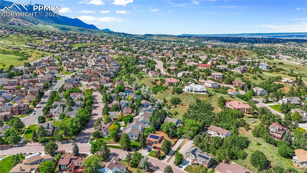 Image 42 of 50: Aerial view of residential area with a mountainous background