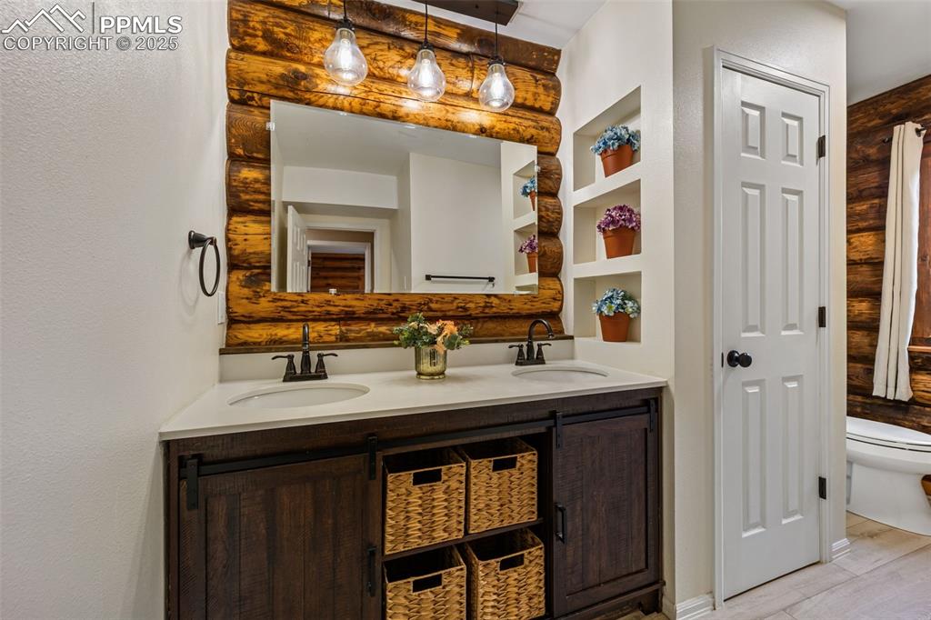 Image 12 of 48: Full bath with double vanity and a textured wall