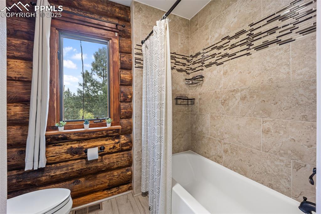 Image 13 of 48: Full bath with shower / tub combo and wood finished floors
