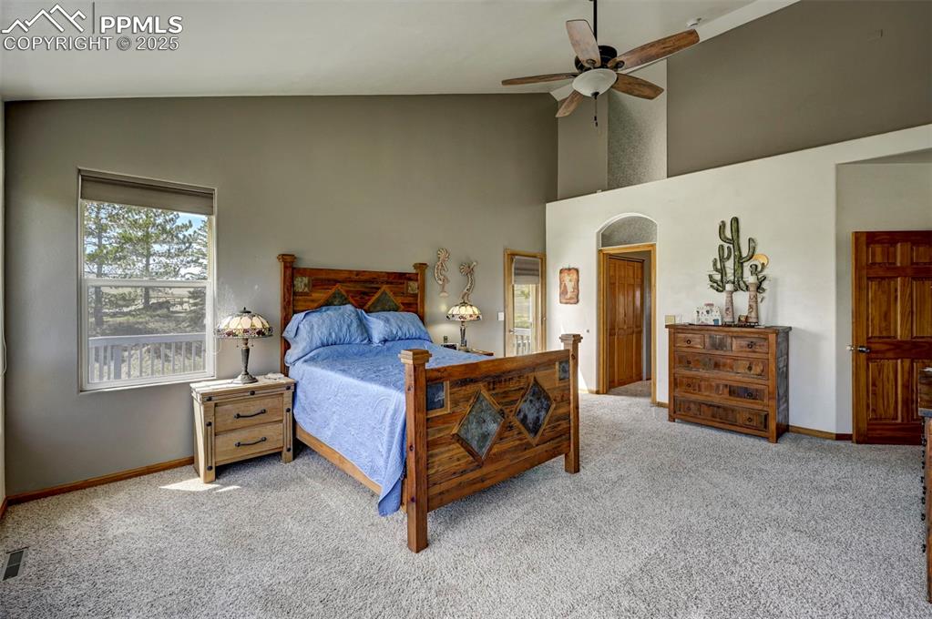 Image 13 of 50: Master bedroom with large windows, vaulted ceilings, adjoining master bathr