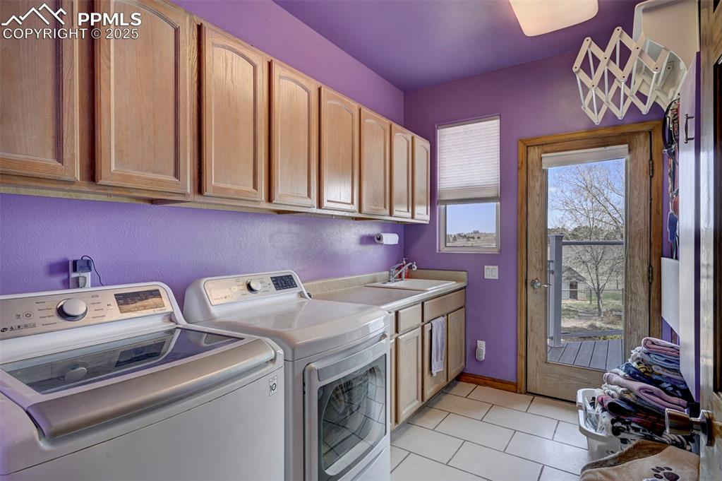 Image 20 of 50: Laundry room on main floor with utility sink and walk out.