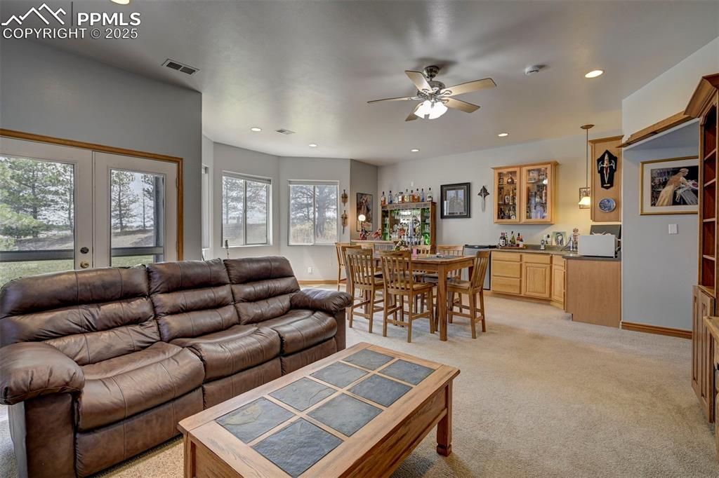 Image 26 of 50: Family room in basement with wet bar and walk out