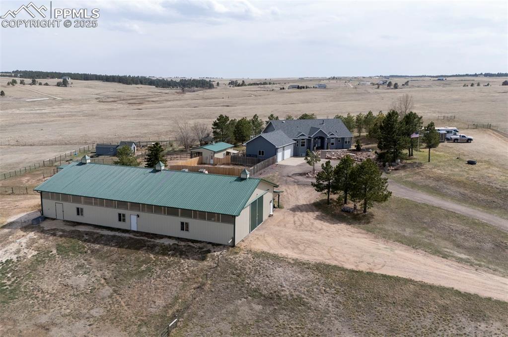 Image 37 of 50: 50x100 metal drive-through barn has a concrete floor, w/ a half bath, 4 sta