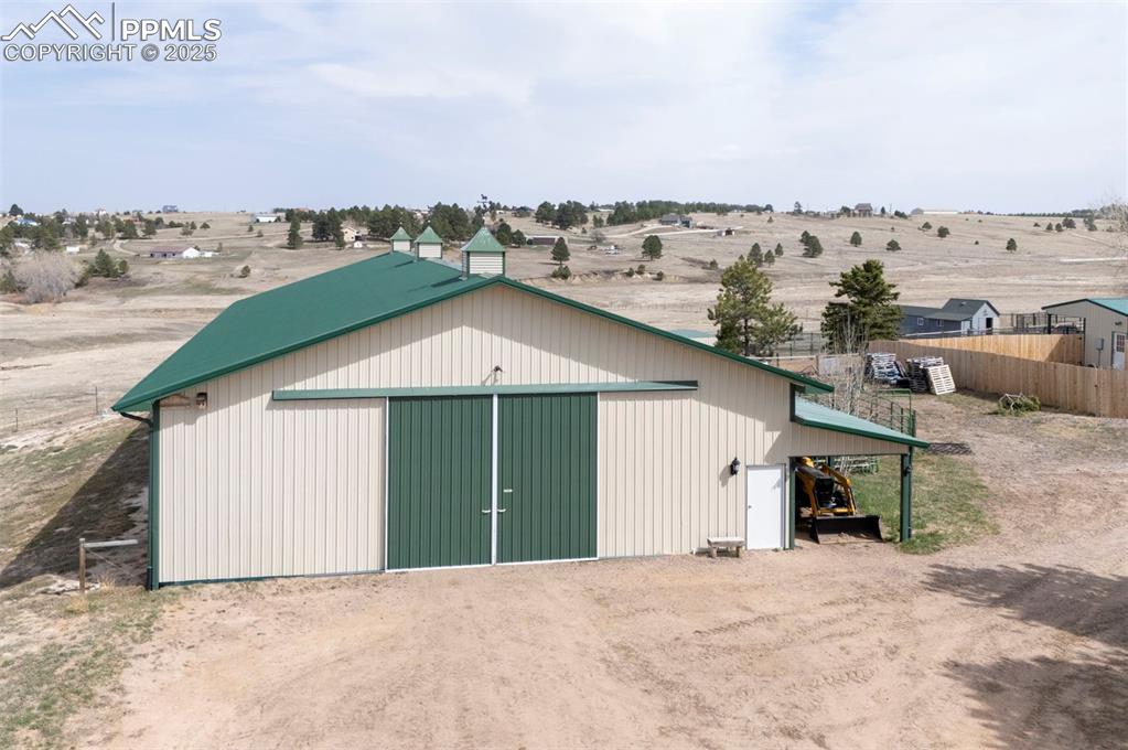 Image 38 of 50: 50x100 metal drive-through barn has a concrete floor, w/ a half bath, 4 sta