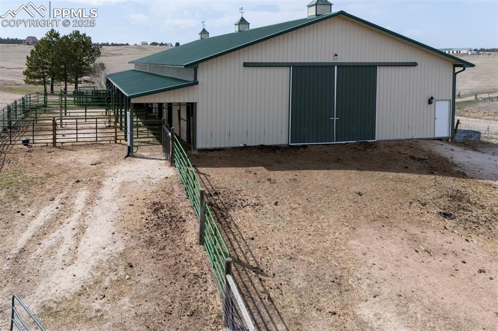 Image 39 of 50: 50x100 metal drive-through barn has a concrete floor, w/ a half bath, 4 sta