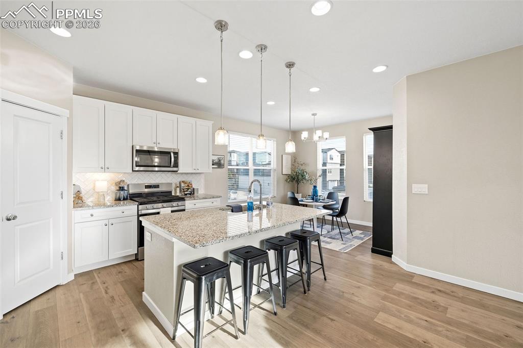 Image 11 of 33: The kitchen features a spacious corner pantry with wood shelving, stainless