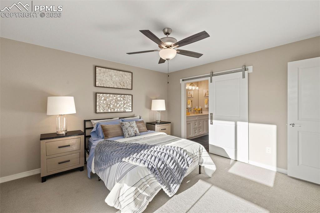 Image 16 of 33: The primary bedroom features an ensuite bathroom with a barn door. 