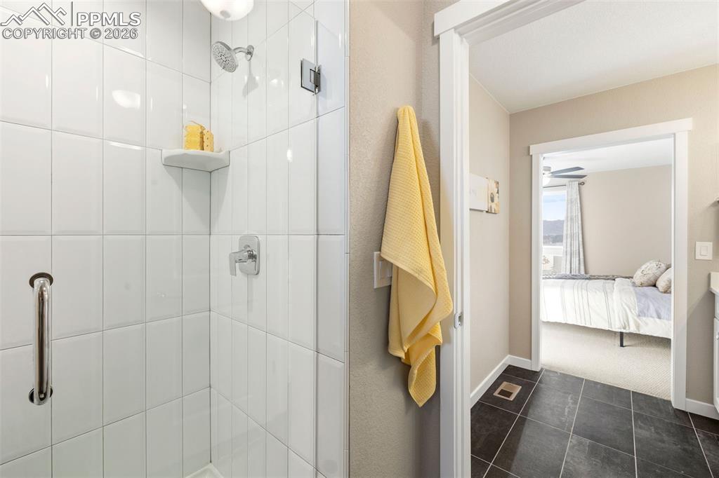 Image 19 of 37: The primary bathroom has an oversized shower with seat, tile floors and an