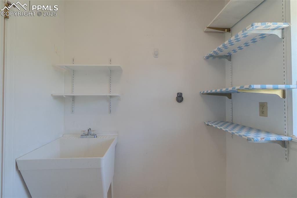 Image 30 of 48: Laundry sink and shelving