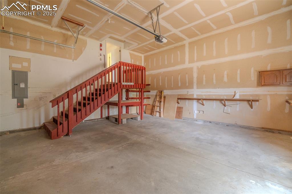 Image 37 of 48: Large finished garage with drywall and shelves