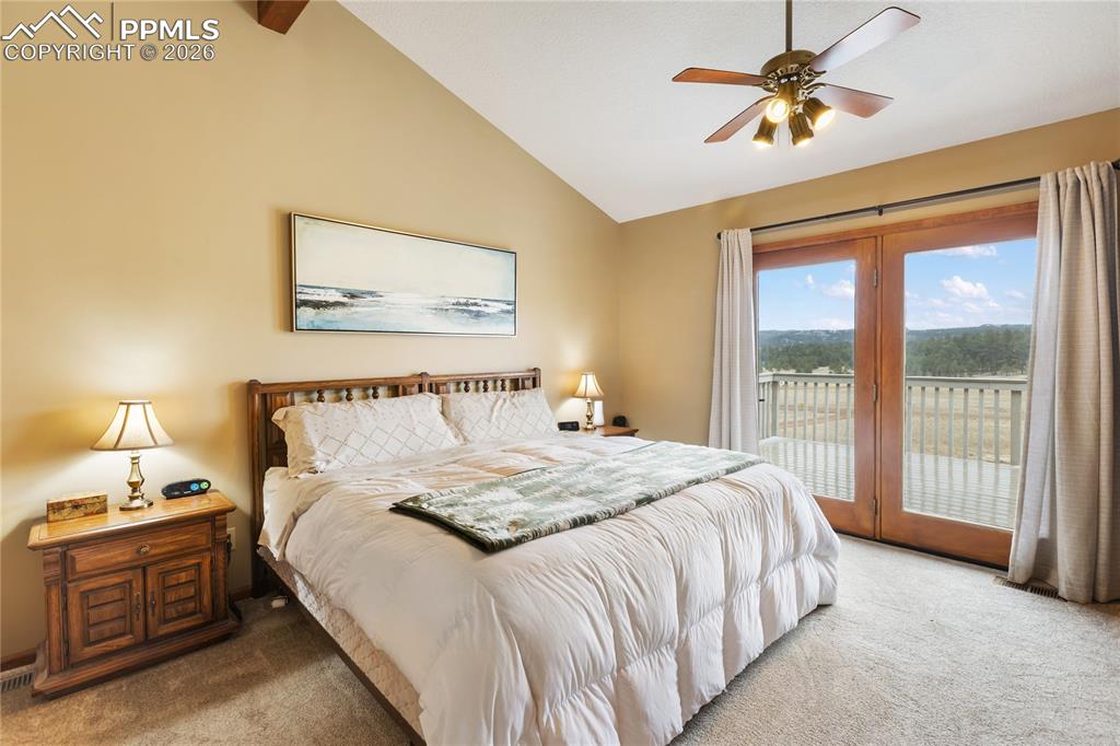 Image 10 of 42: The main bedroom has a vaulted ceiling with a rich wooden beam and a ceilin